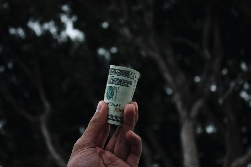 How much does it cost to service my watch? A hand holding a wad of dollars